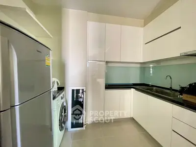 Modern kitchen with sleek white cabinets and stainless steel appliances