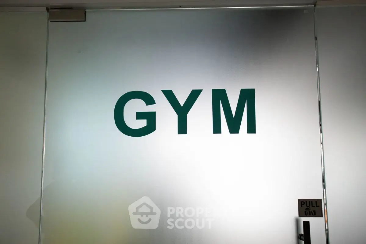 Modern gym entrance with frosted glass door and bold signage
