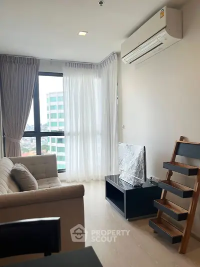 Modern living room with large window and air conditioning in a high-rise apartment.