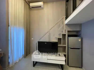 Modern living room with loft, TV, and sleek fridge in stylish apartment