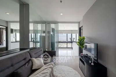 Modern living room with sleek design and stunning city view through large windows.