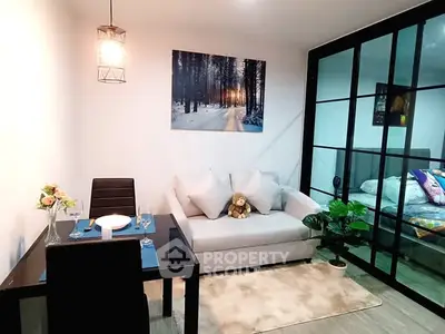 Modern living room with dining area and glass partition to bedroom, stylish decor.