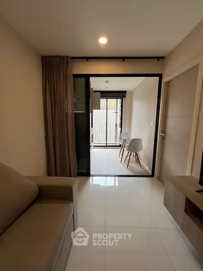 Modern living room with sliding glass doors leading to a cozy balcony area.