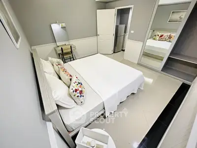 Modern bedroom with sleek design, mirrored wardrobe, and cozy decor