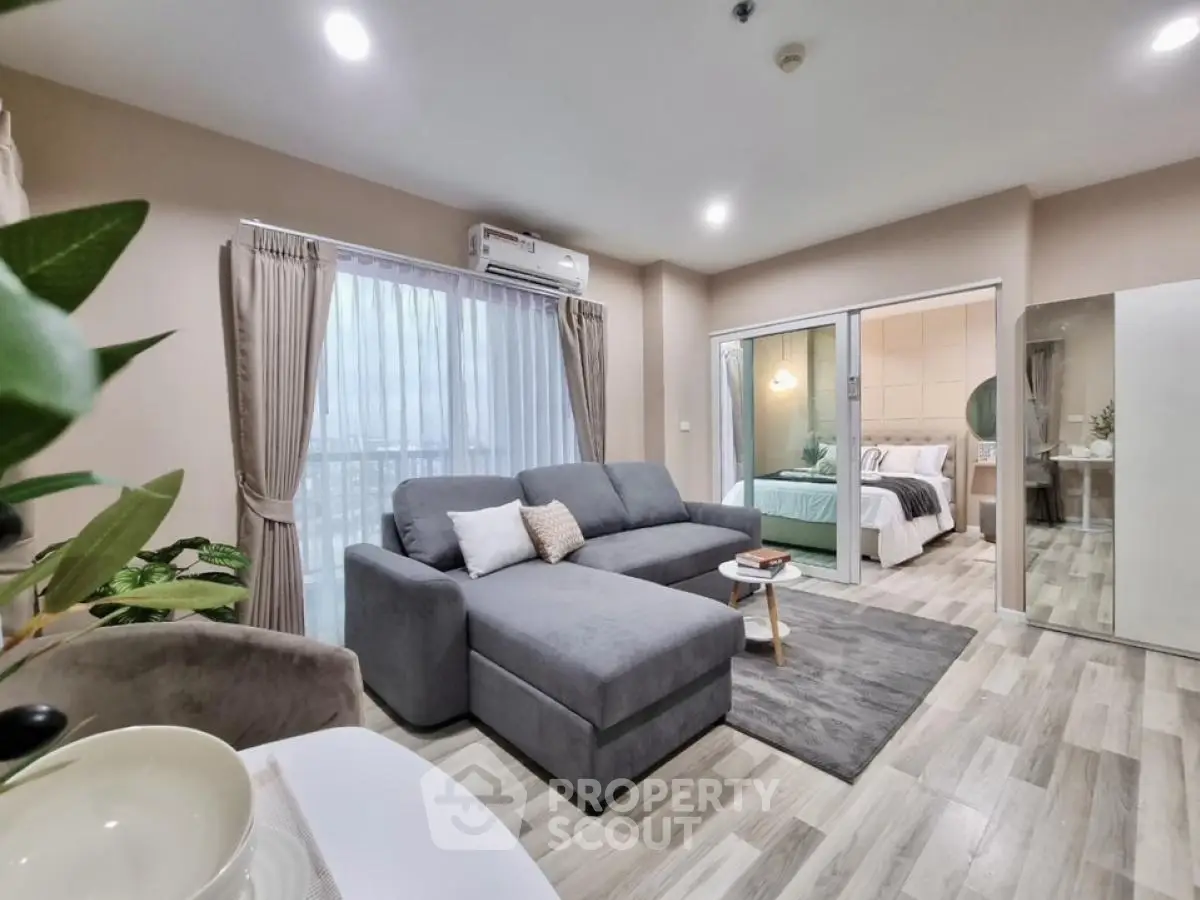 Modern open-plan living room with cozy gray sofa and stylish decor