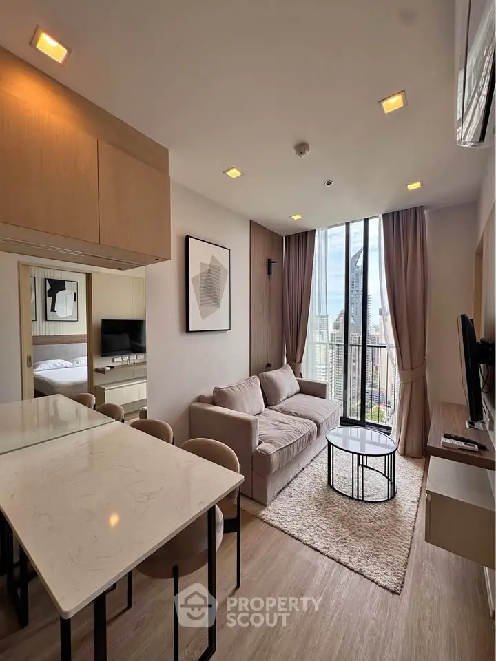 Modern living room with city view, cozy sofa, and stylish decor in a high-rise apartment.