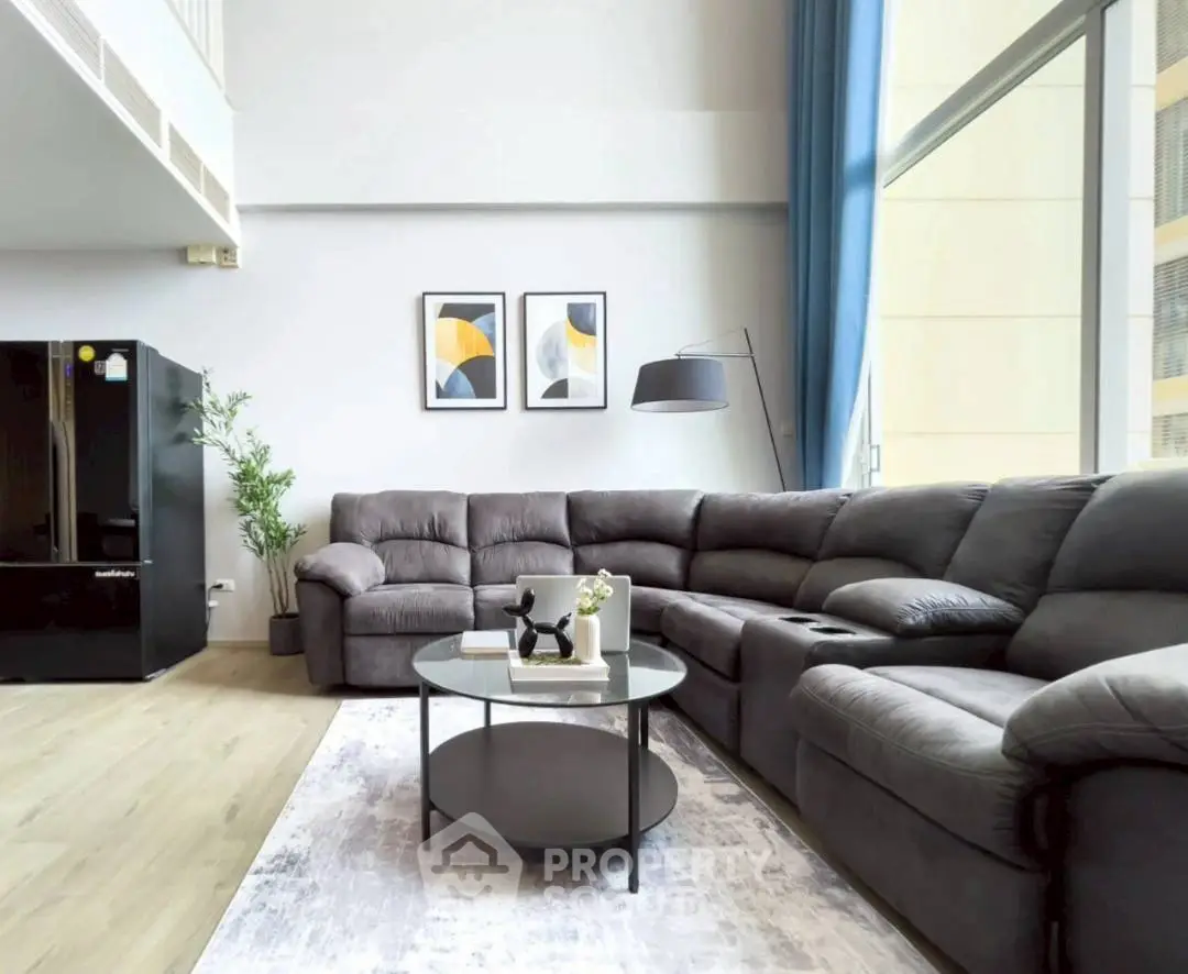 Spacious modern living room with plush sectional sofa and large windows