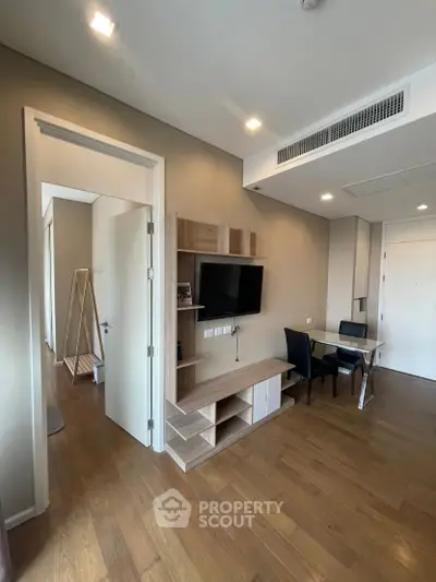 Modern living room with wooden flooring and sleek furniture in a stylish apartment.