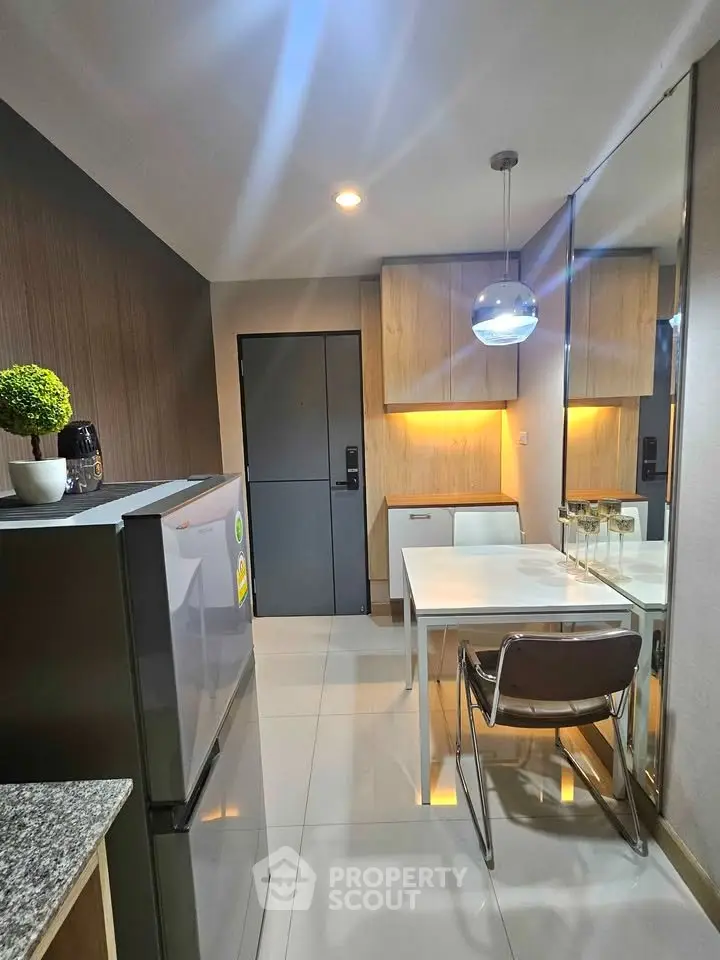 Modern kitchen with sleek design, featuring stainless steel fridge and stylish dining area.