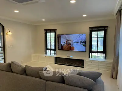 Luxurious living room with modern decor and large TV, perfect for relaxation and entertainment.