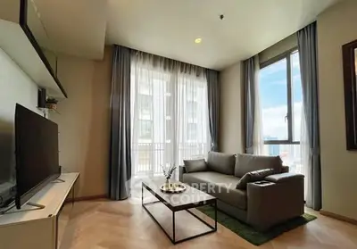 Modern living room with large windows and stylish furniture in a high-rise apartment.