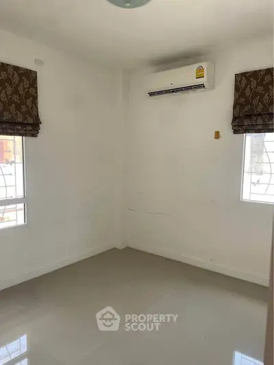 Spacious empty room with air conditioning and natural light, perfect for customization.