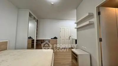 Spacious bedroom with modern furnishings and ample storage in a stylish apartment.