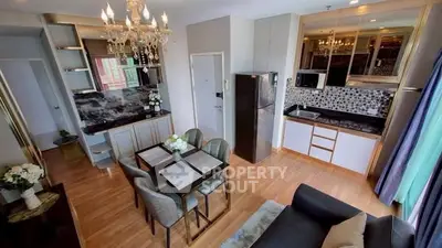 Luxurious open-layout kitchen and dining area with elegant chandelier and modern appliances.
