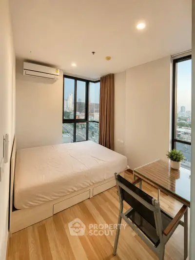 Modern bedroom with city view, featuring large windows, wooden flooring, and minimalist furniture.