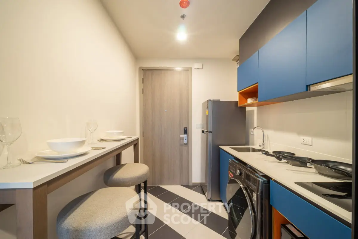 Modern compact kitchen with sleek appliances and stylish bar seating