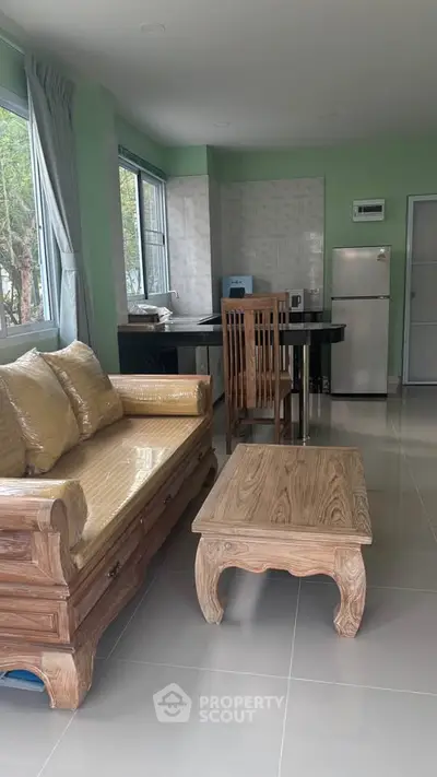 Spacious living room with wooden furniture and modern kitchen appliances