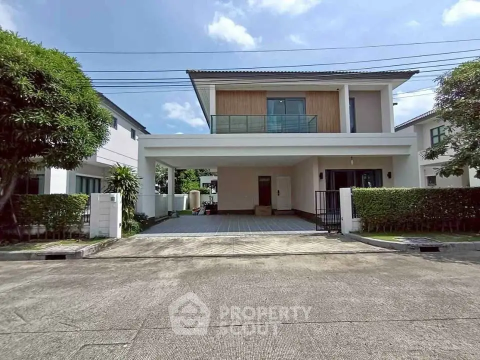 Modern two-story house with spacious driveway and lush greenery