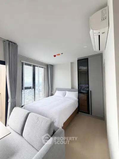 Modern bedroom with city view, featuring sleek design and ample natural light.
