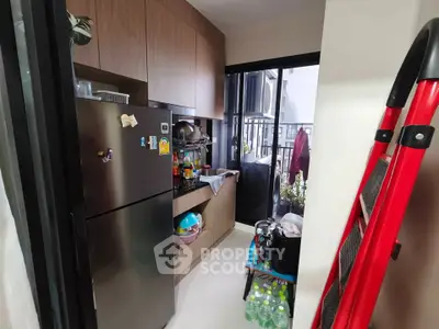 Compact kitchen with modern appliances and balcony access in urban apartment