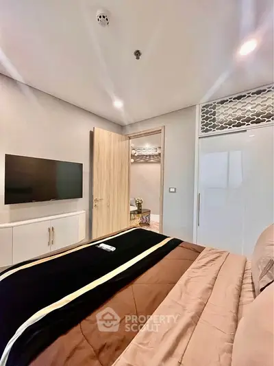 Modern bedroom with sleek design, featuring a wall-mounted TV and stylish decor.