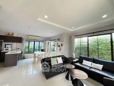 Spacious open-plan living room with modern kitchen and garden view.