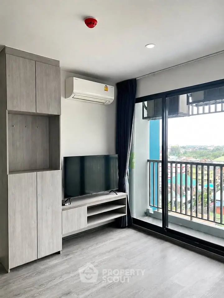 Modern living room with large windows and balcony view in a stylish apartment.