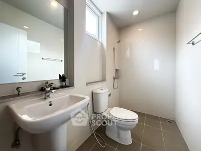 Modern bathroom with sleek fixtures and large mirror in a bright, minimalist design.