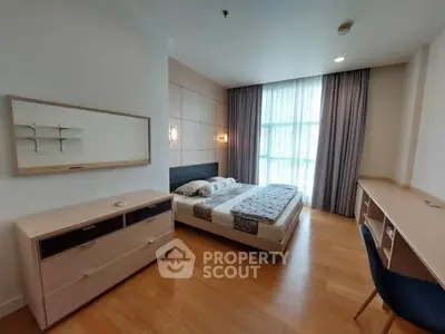 Spacious modern bedroom with large window and elegant furnishings