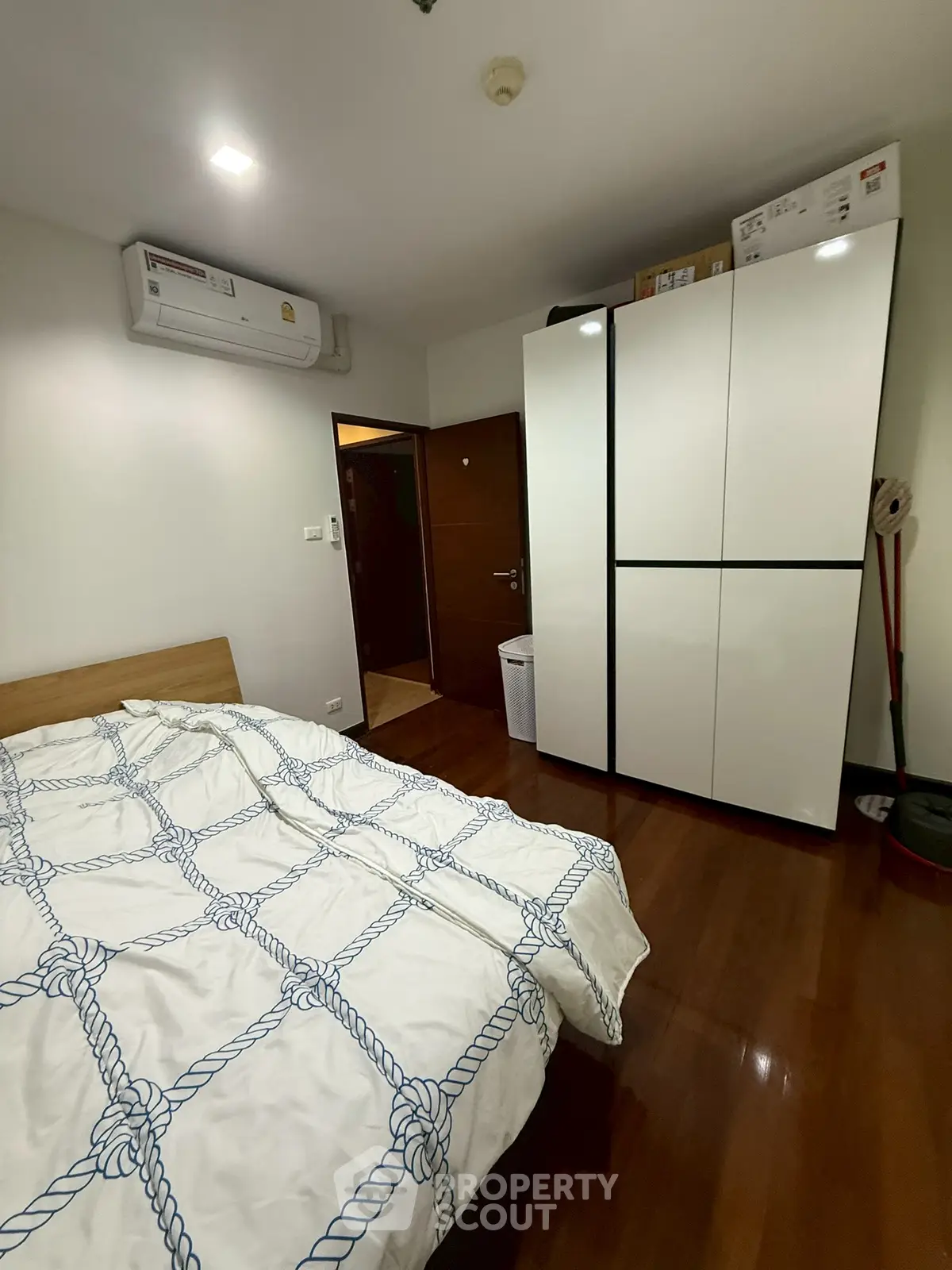 Cozy bedroom with modern wardrobe and air conditioning, perfect for comfortable living.