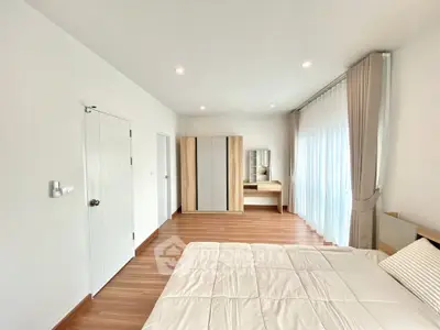 Spacious bedroom with modern decor and large windows for natural light