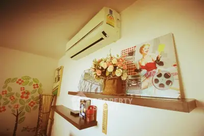 Charming interior with wall art and air conditioning, perfect for cozy living spaces.