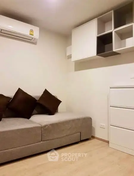 Cozy living room with modern sofa and wall-mounted storage in a minimalist design.