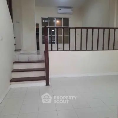 Spacious split-level living area with tiled flooring and air conditioning.