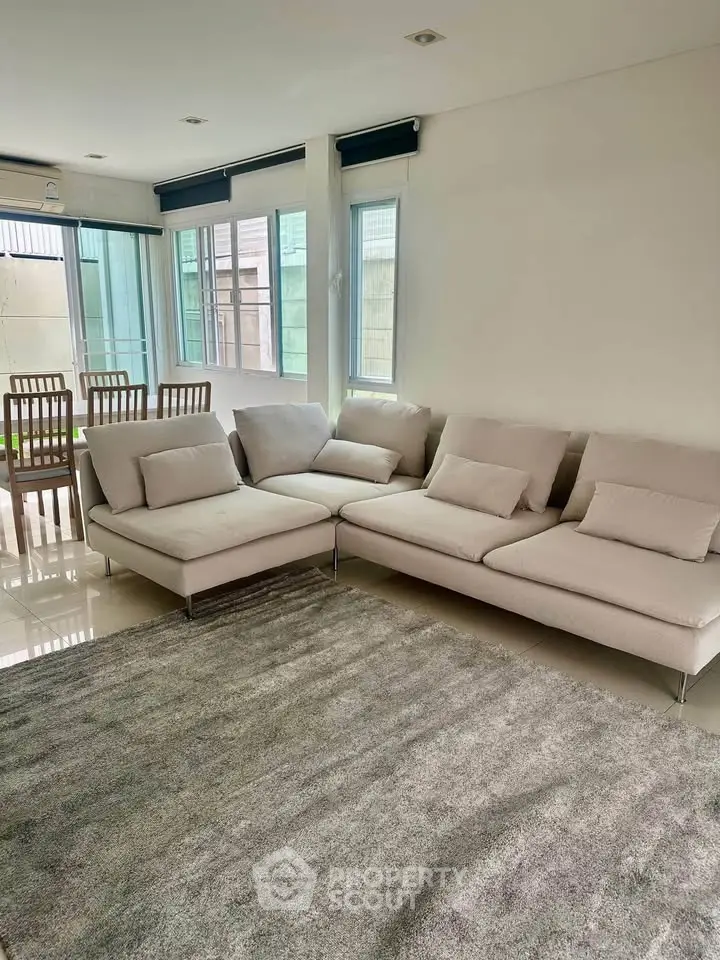 Spacious living room with modern sectional sofa and large windows