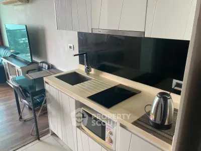 Modern kitchen with sleek cabinetry, induction cooktop, and integrated appliances in a stylish apartment.