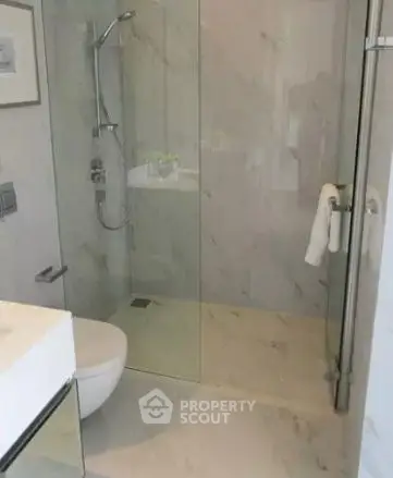 Modern bathroom with glass shower and marble tiles