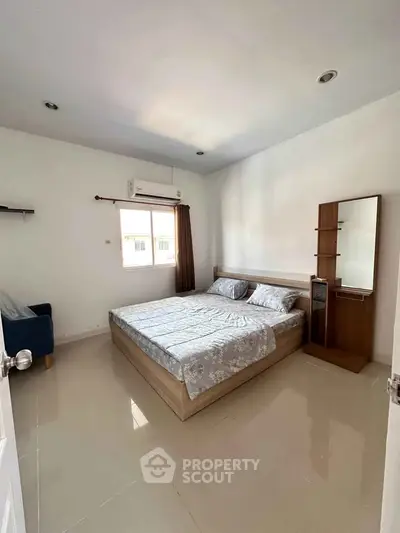 Spacious bedroom with modern furnishings and natural light in a stylish apartment.