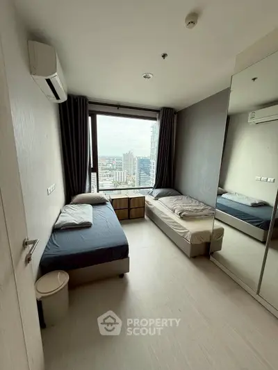 Modern bedroom with twin beds and city view, ideal for urban living.