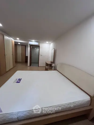 Spacious bedroom with modern furniture and ample storage space