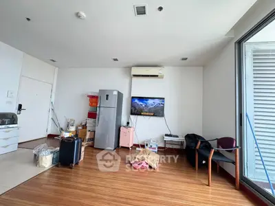 Spacious living room with modern appliances and large window for natural light.