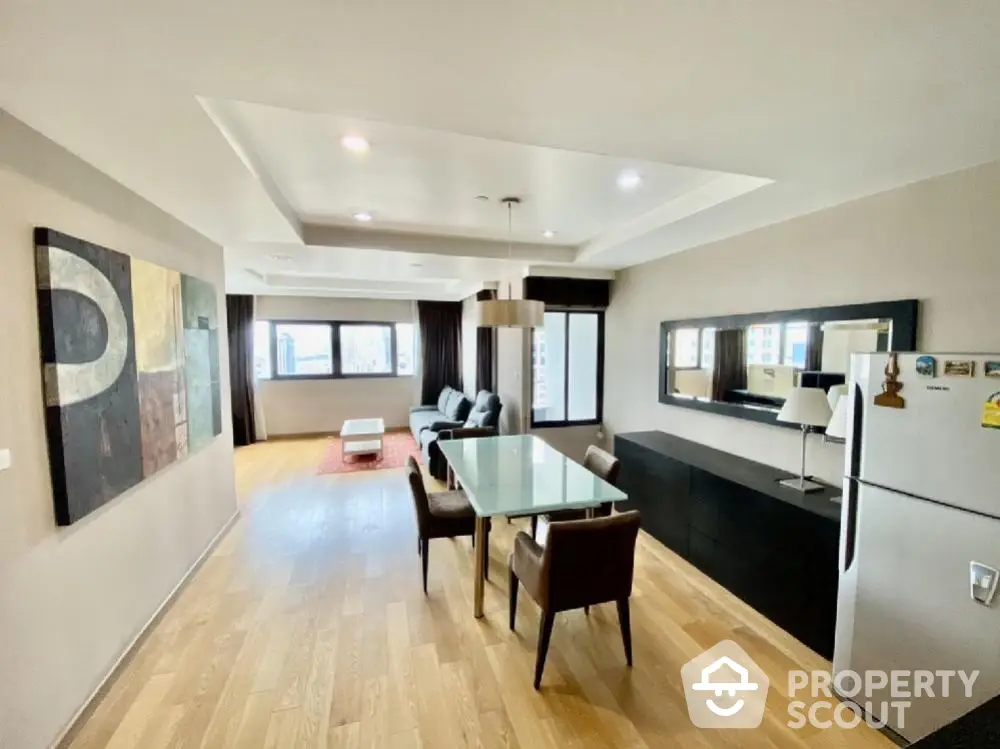 Spacious modern living room with dining area and large windows in a stylish apartment.