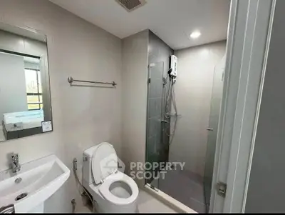 Modern bathroom with glass shower and sleek fixtures in a contemporary apartment.