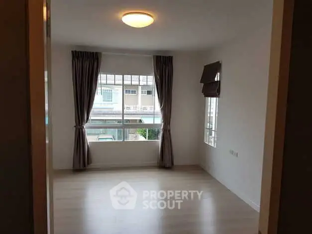 Spacious empty room with large window and elegant curtains