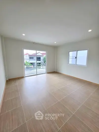 Spacious empty room with large windows and balcony view, perfect for customization.