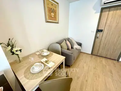 Cozy living room with dining area, modern decor, and wooden flooring in a stylish apartment.
