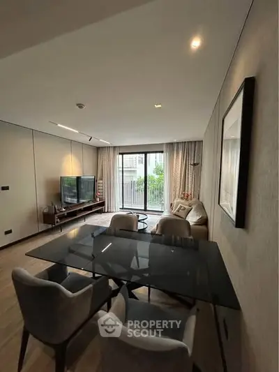 Modern living room with sleek furniture and large windows offering natural light.