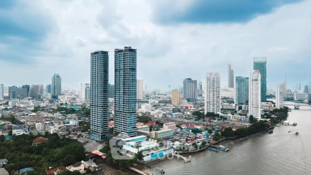 Stunning aerial view of modern high-rise buildings along a river in a bustling cityscape.