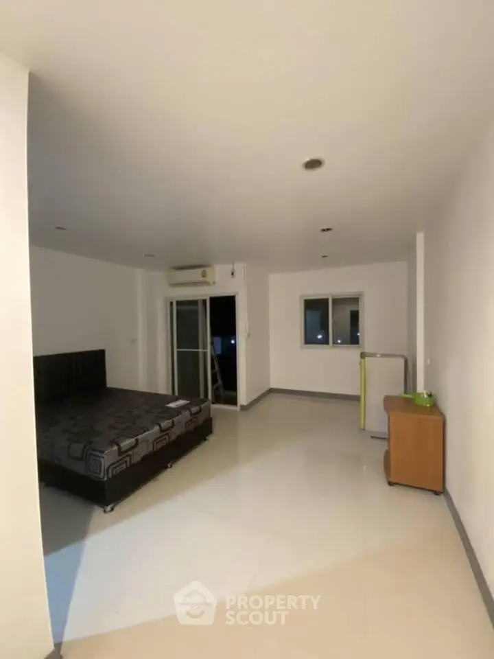 Spacious bedroom with modern design and large windows for natural light.