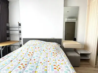 Modern bedroom with stylish decor and ample natural light, featuring a cozy bed and sleek furniture.